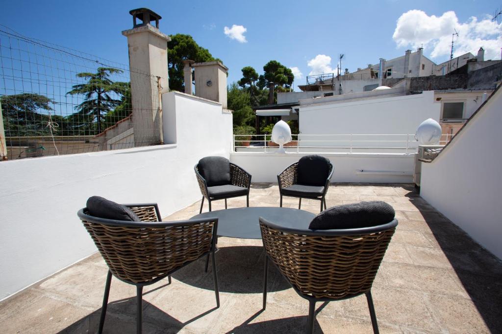 a patio with chairs and a table on a roof at Suite San Gaetano in Conversano