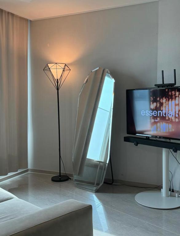 a living room with a television and a lamp at 광안비치스테이&Spa in Kwangan-dong