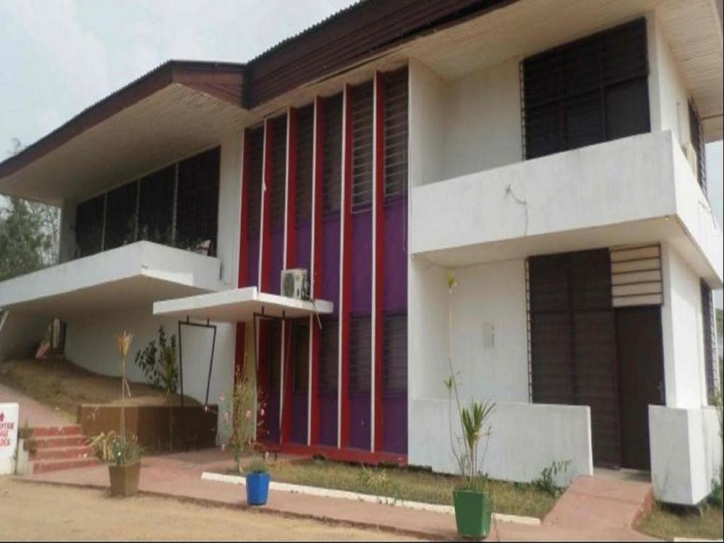 a building with red and purple doors on it at Kokodo Guest House in Cape Coast