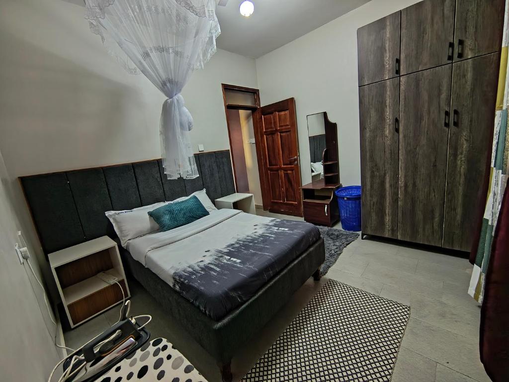 a bedroom with a bed with a dresser and a mirror at Vine Suites Mbarara Fully Furnished 1BR - Ideal for Short & Long Stays in Mbarara