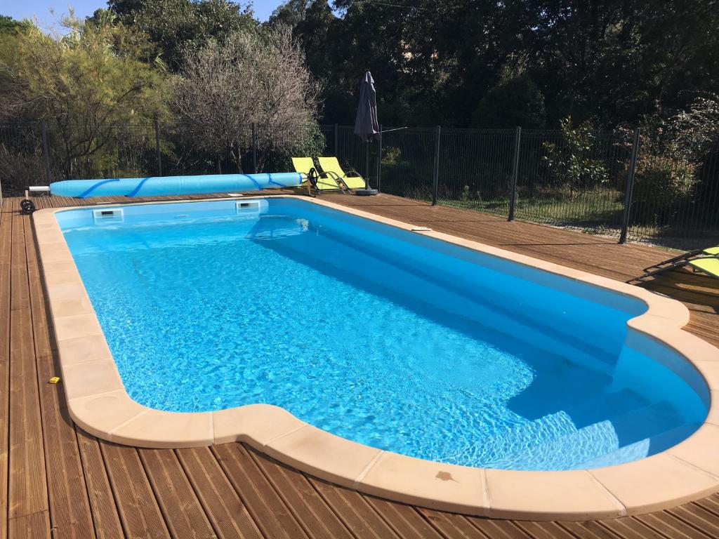 una piscina en una terraza de madera con una piscina azul en Les Mimosas Apartments, en Villelongue-dels-Monts