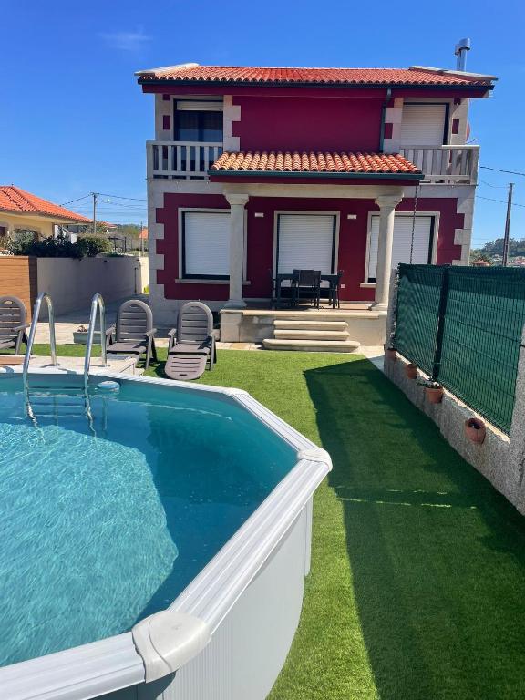 a house with a swimming pool in front of a house at Chalet Bordones Playa in Bordons