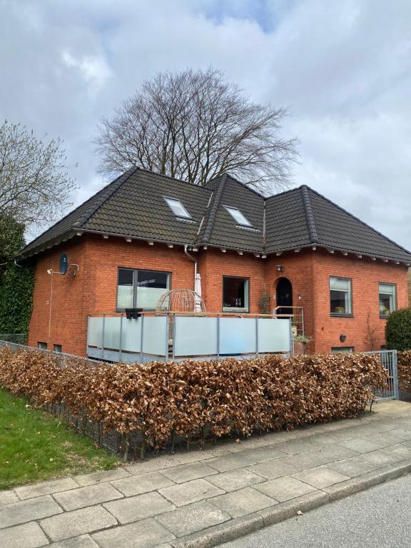 a red brick house with a black roof at Skøn lejlighed i centrum in Herning
