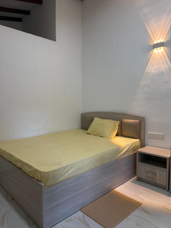 a bed in a room with a white wall at Hantana Villa in Kandy