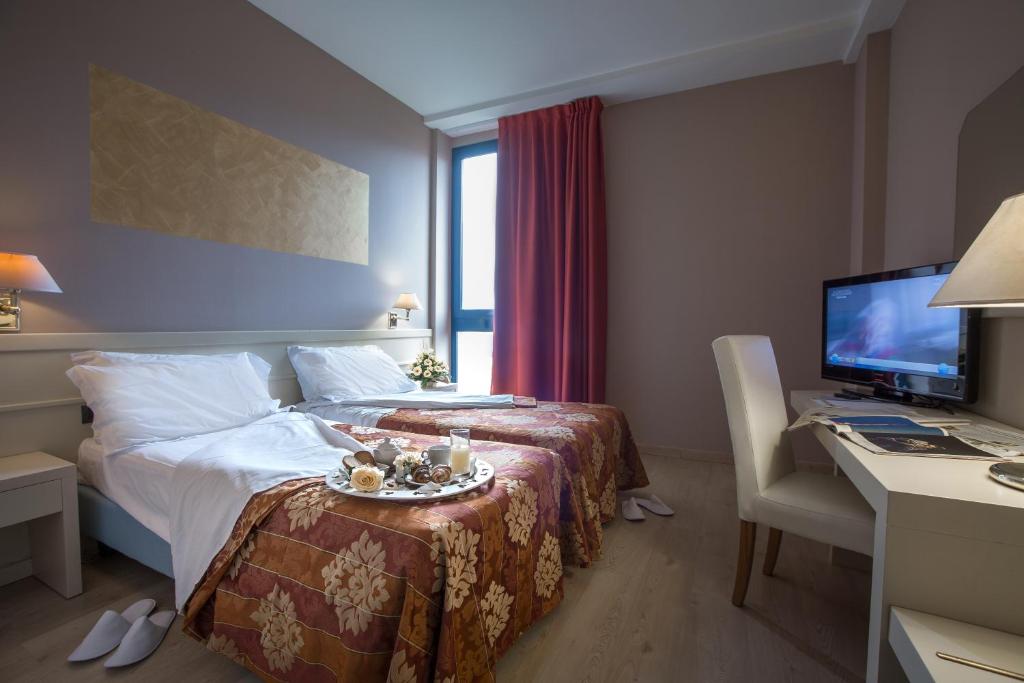 カーシナにあるEuro Hotelのベッド、デスク、コンピュータが備わる客室です。