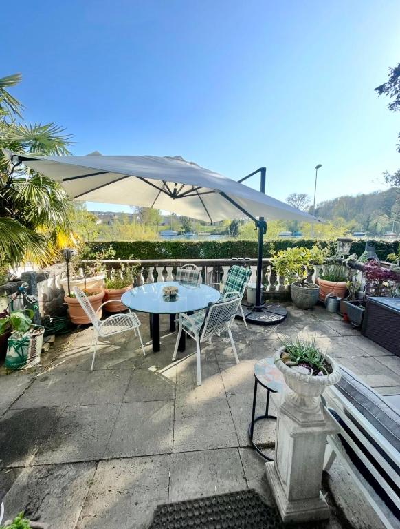 a patio with a table and chairs and an umbrella at Lake apartment with terrace in Nidau