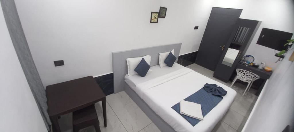 a small room with a bed and a table at Hotel Bougainvillea in Cochin