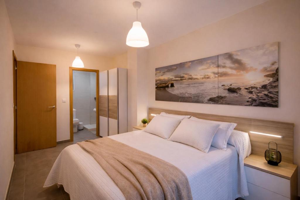 a bedroom with a bed and a painting on the wall at Nova MSuites Xove in Lago