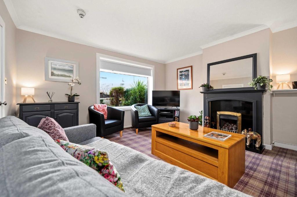 a living room with a couch and a fireplace at 4-Bed Home Central Location & Garden in Oban
