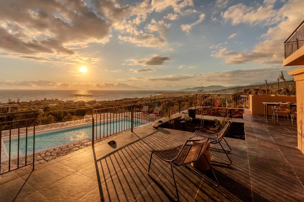 a balcony with a view of the ocean at sunset at Thalassori Villas in Agios Nikolaos