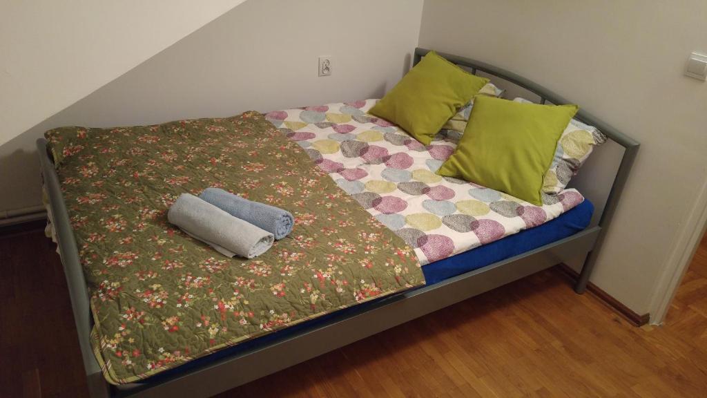 - un lit avec une couverture et des oreillers dans l'établissement Rent0nline Brwinow Rooms, à Brwinów