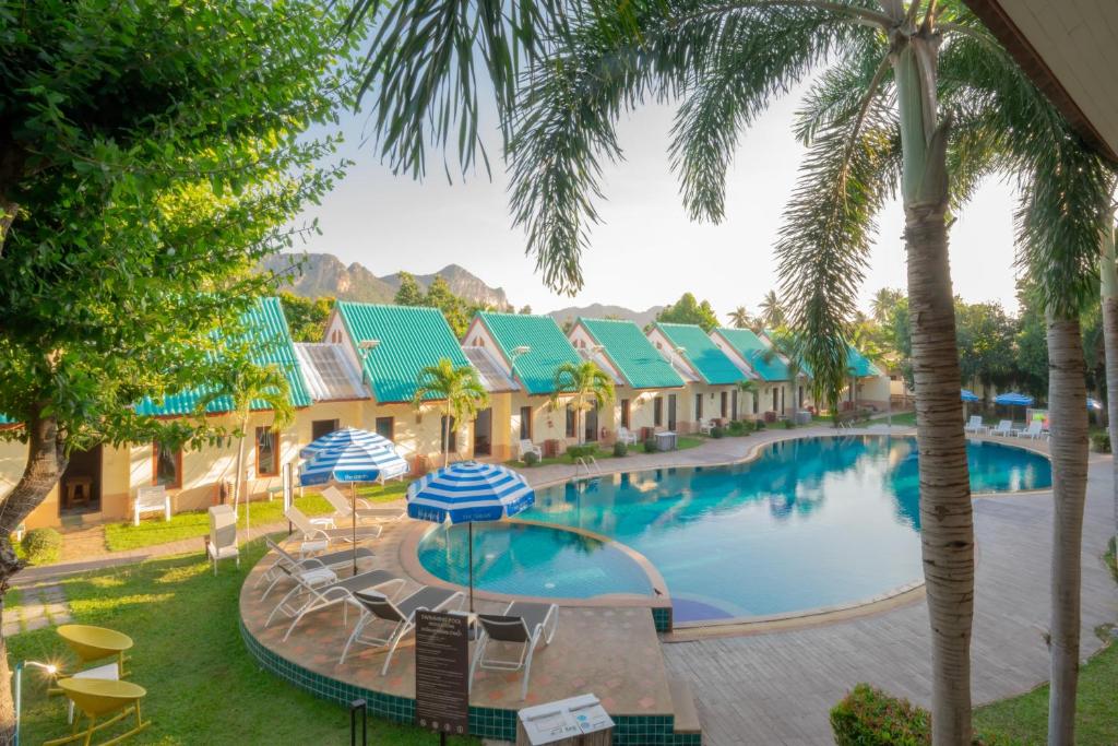 a view of a pool at a resort with palm trees at The Green Beach Resort in Sam Roi Yot