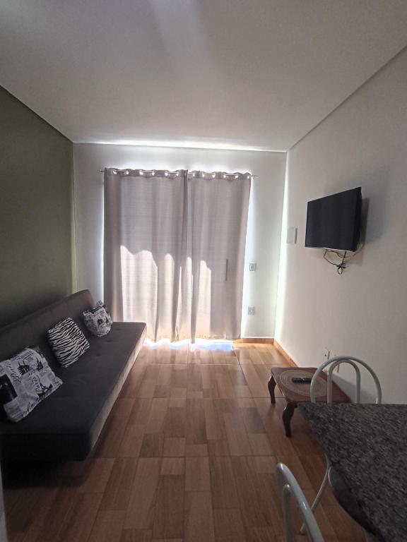 a living room with a couch in front of a window at Apartamento Indaiatuba in Indaiatuba