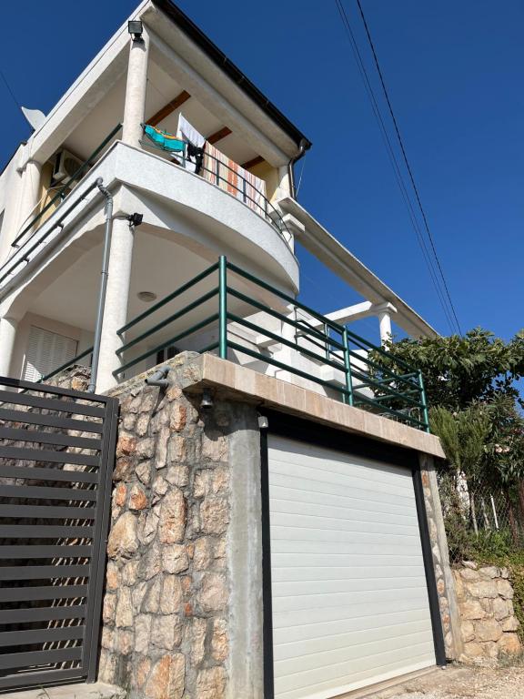 a white garage door on a house with a balcony at Apartments Nenadić in Utjeha