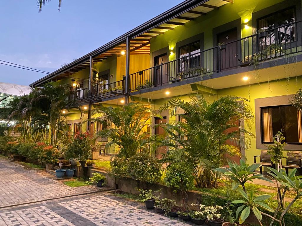 a yellow building with plants in front of it at The Paramount Lodge & Villas in Polonnaruwa