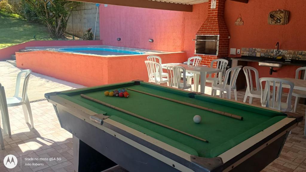 a pool table in front of a swimming pool at Estação lazer e Eventos in Mairinque