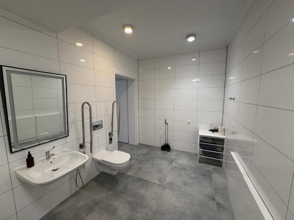 a white bathroom with a toilet and a sink at WiLDBED DE Mitte in Bad Wildbad