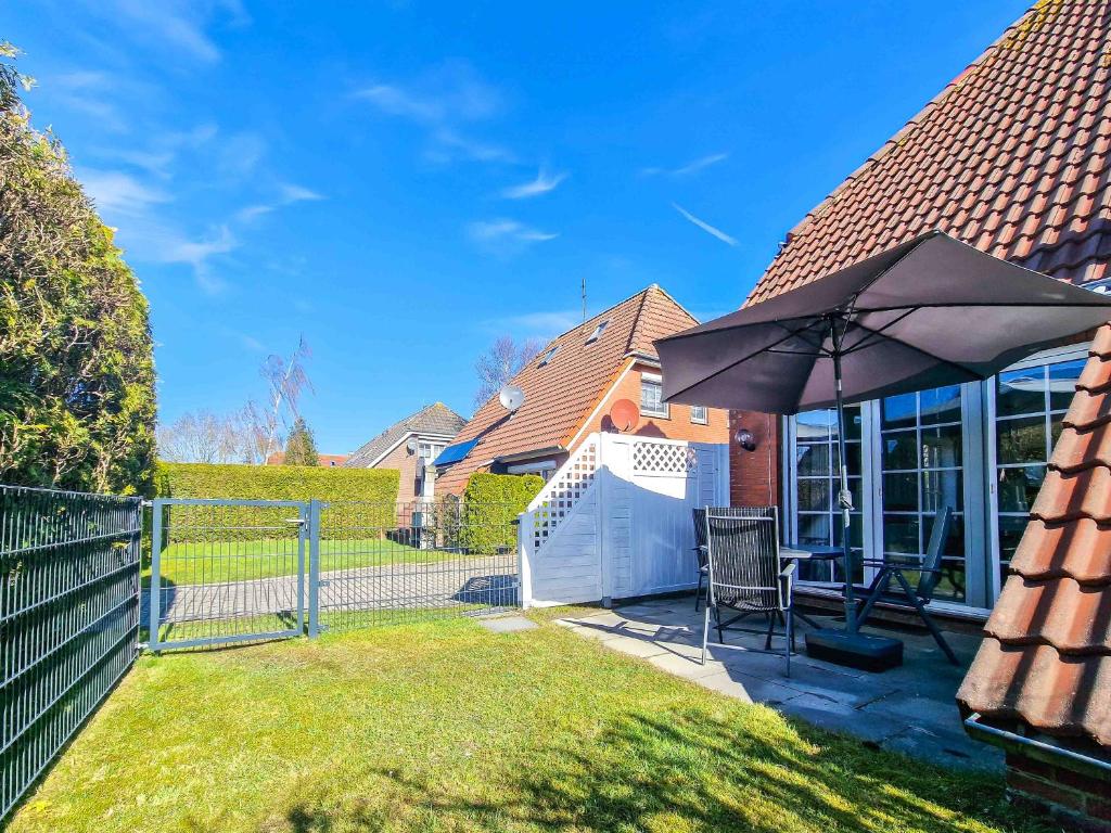 a patio with an umbrella in a yard at Strandkrabbe in Greetsiel