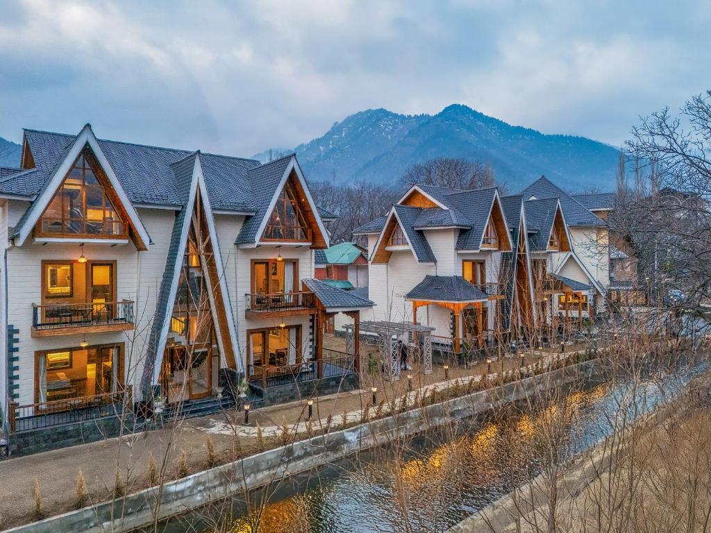 a row of houses next to a river at The Harmukh Hills in Batakūt
