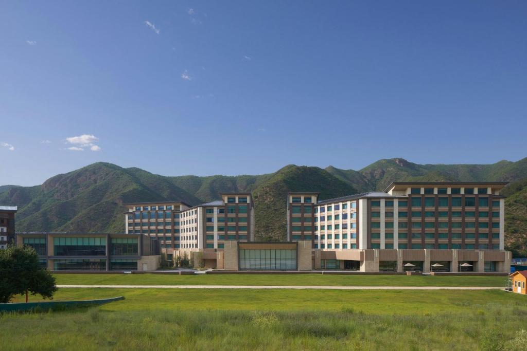 a group of buildings with mountains in the background at Courtyard by Marriott Chongli in Zhangjiakou