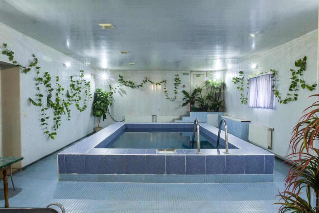 a bathroom with a tub with plants on the wall at Motel Lesnoy in Odintsovo