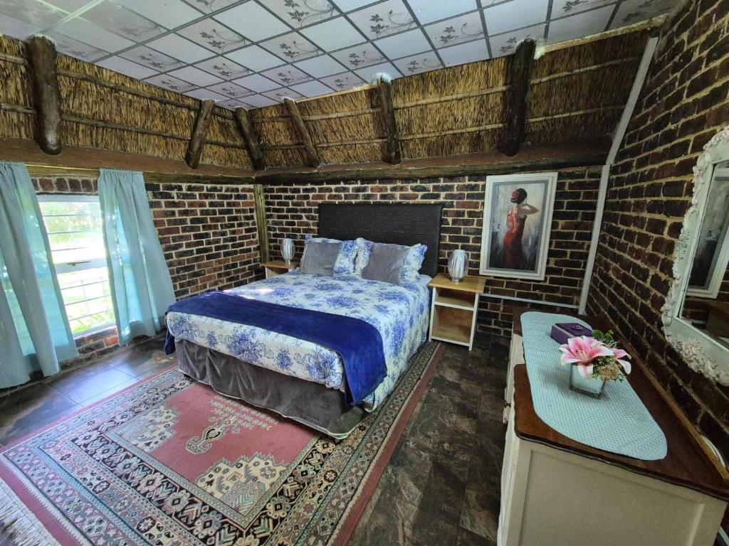 a bedroom with a bed and a brick wall at Midvaal Guesthouse in Meyerton