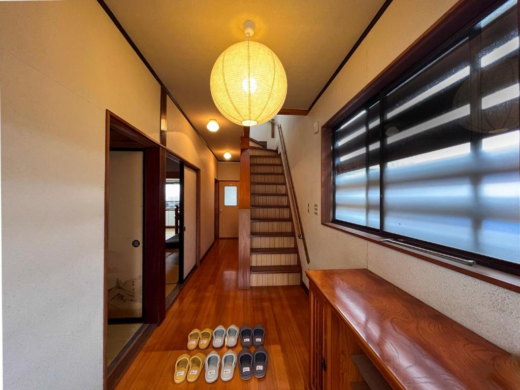 a hallway of a house with a staircase and a window at Tani House Tokiwa Nozawa Onsen & More in Iiyama
