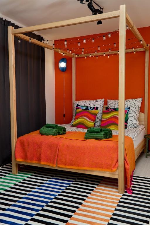 a bedroom with a canopy bed with an orange wall at 2 OG HbF Wuppertal DomusKushal in Wuppertal
