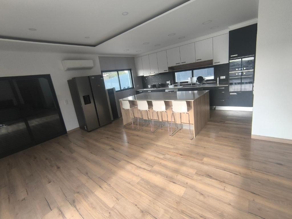 a kitchen with a counter and chairs in a room at Residência SB in Odivelas