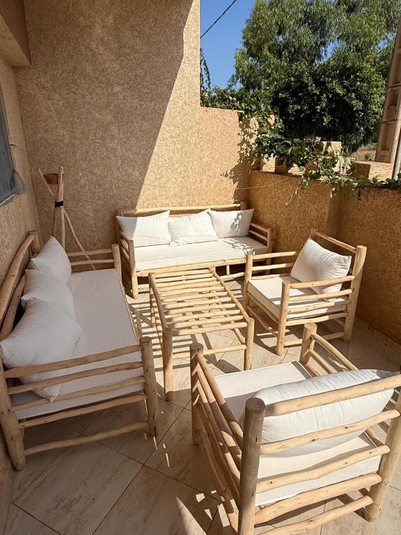 a group of wooden chairs and tables on a patio at Saidia appart in Saïdia