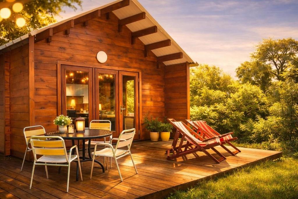 a cabin with a table and chairs on a deck at Chalet Pondok Indah in Plouégat-Moysan