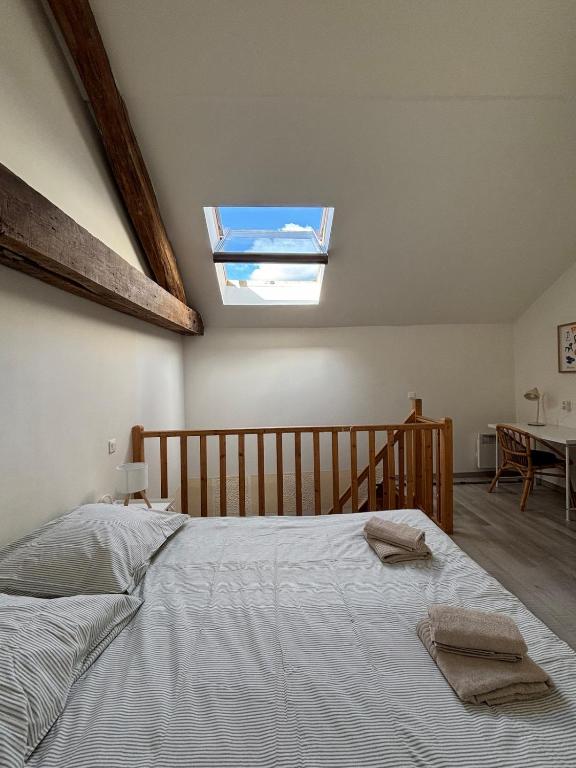 a bedroom with a large bed with a skylight at L'Aile de Fontainebleau in Fontainebleau