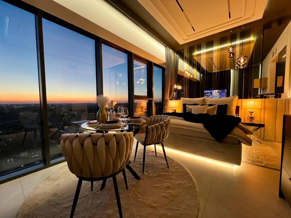 a bedroom with a bed and a table and chairs at Sky Suite 22 Hanza Tower in Szczecin