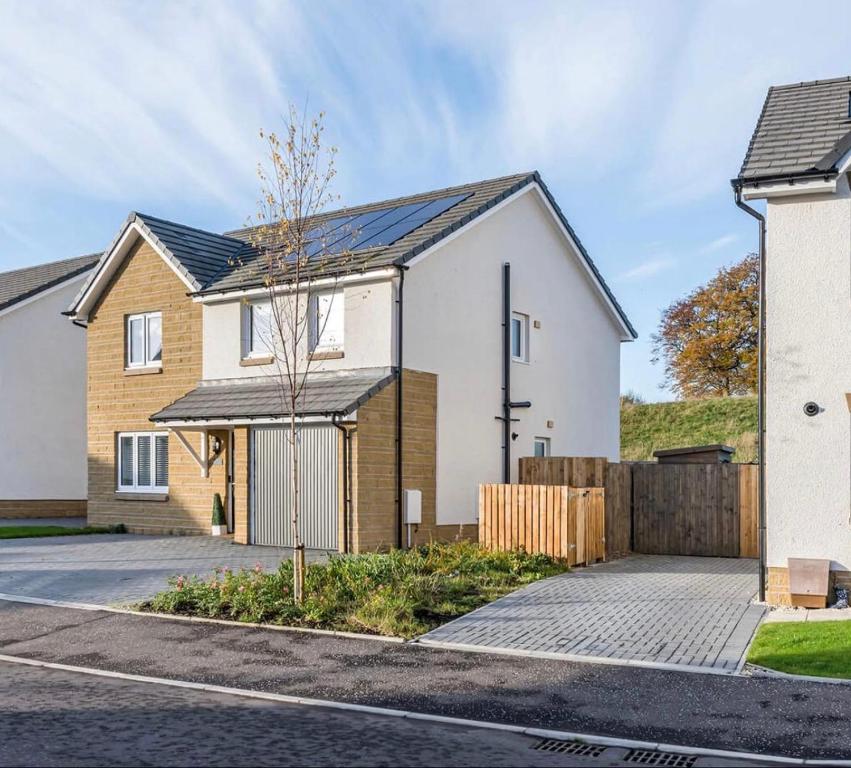 a white house with a black roof at Gilded Nest-Room with Detached Bath- Ideal for ONE- WIFI, Car Parking-Shared House in Newarthill