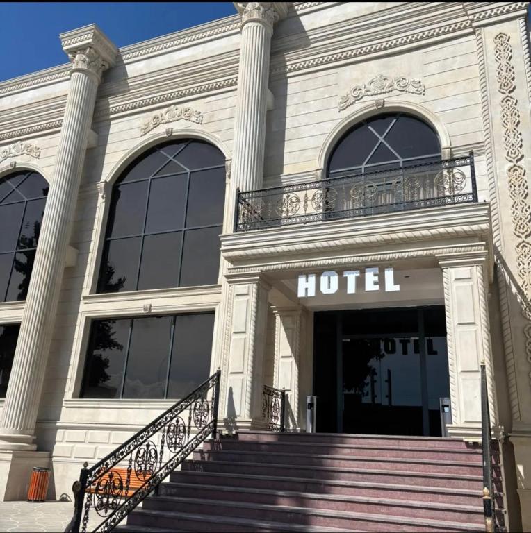 a hotel building with stairs in front of it at Grand Teatro Hotel in Ganja