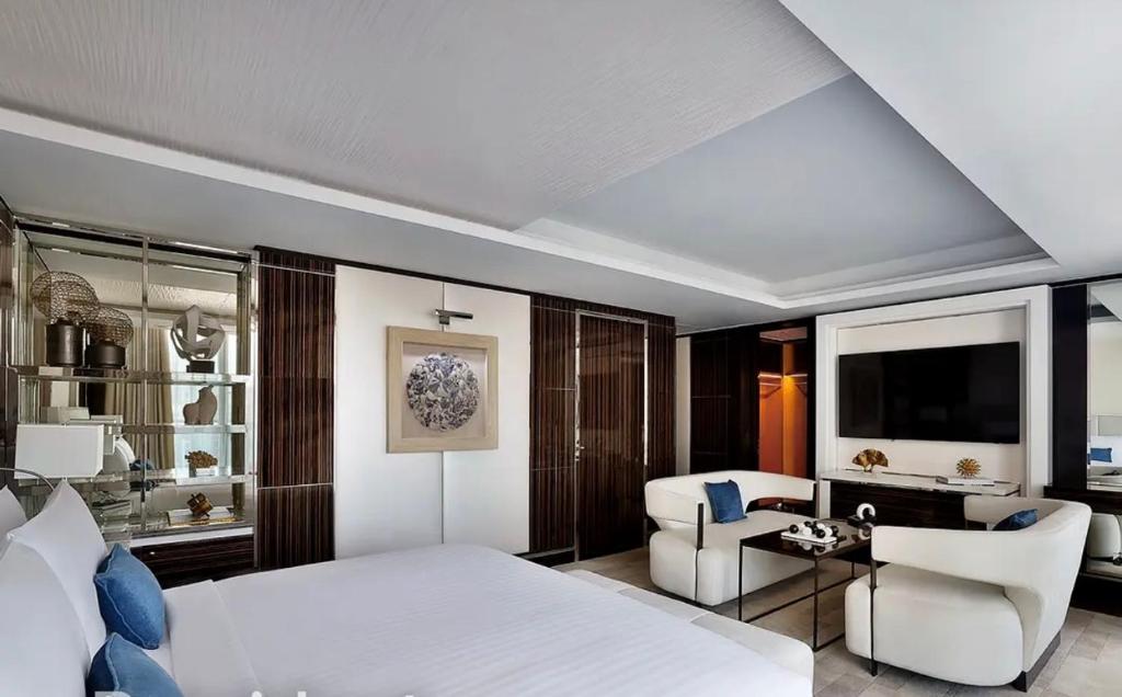a bedroom with a large white bed and a living room at Villa Alfa Kosta in Cairo