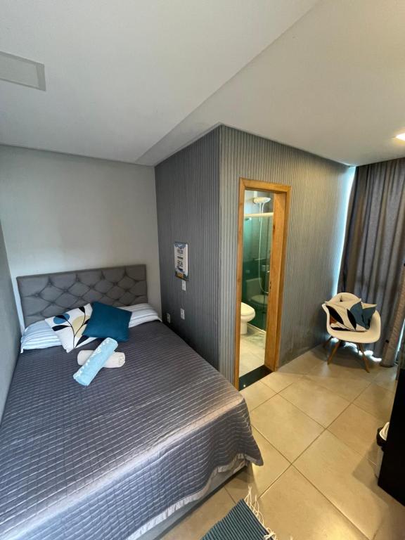 a bedroom with a bed and a chair in it at Studio compacto em Camboriú in Camboriú
