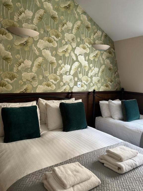 a hotel room with two beds with towels on them at The Marker Hotel in London