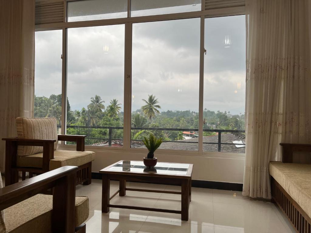 a living room with a table and a large window at Cottage Fifty One in Kandy