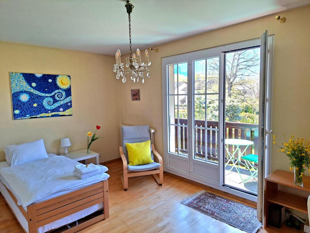 a bedroom with a bed and a chair and a window at respite finaly in Geneva