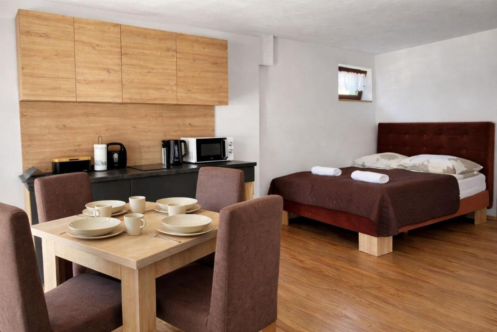 a room with a table and a bed and a table and chairs at Willa Magda in Jastrzębia Góra
