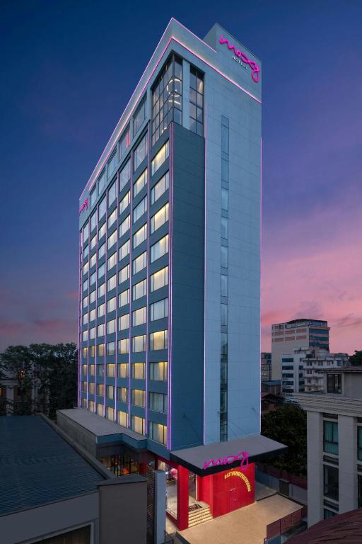 a tall building with a lit up sign on it at Moxy Kathmandu in Kathmandu