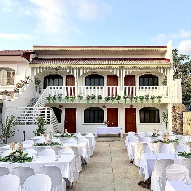 a group of tables with white tablesearcher at BeaMare Suites in Bantay
