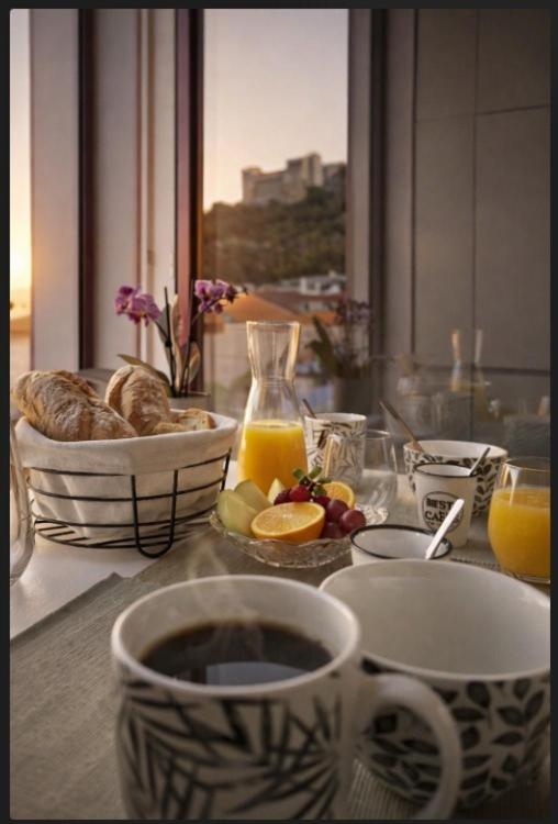 a table with a cup of coffee and a bowl of fruit at Castle Boutique Studio in Leiria