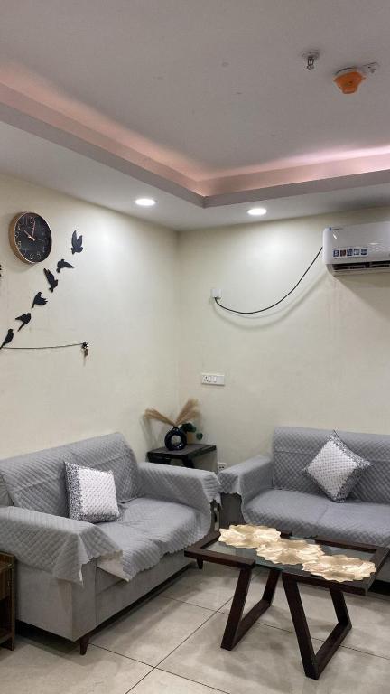 a living room with two couches and a table at The Horizon House in Zirakpur