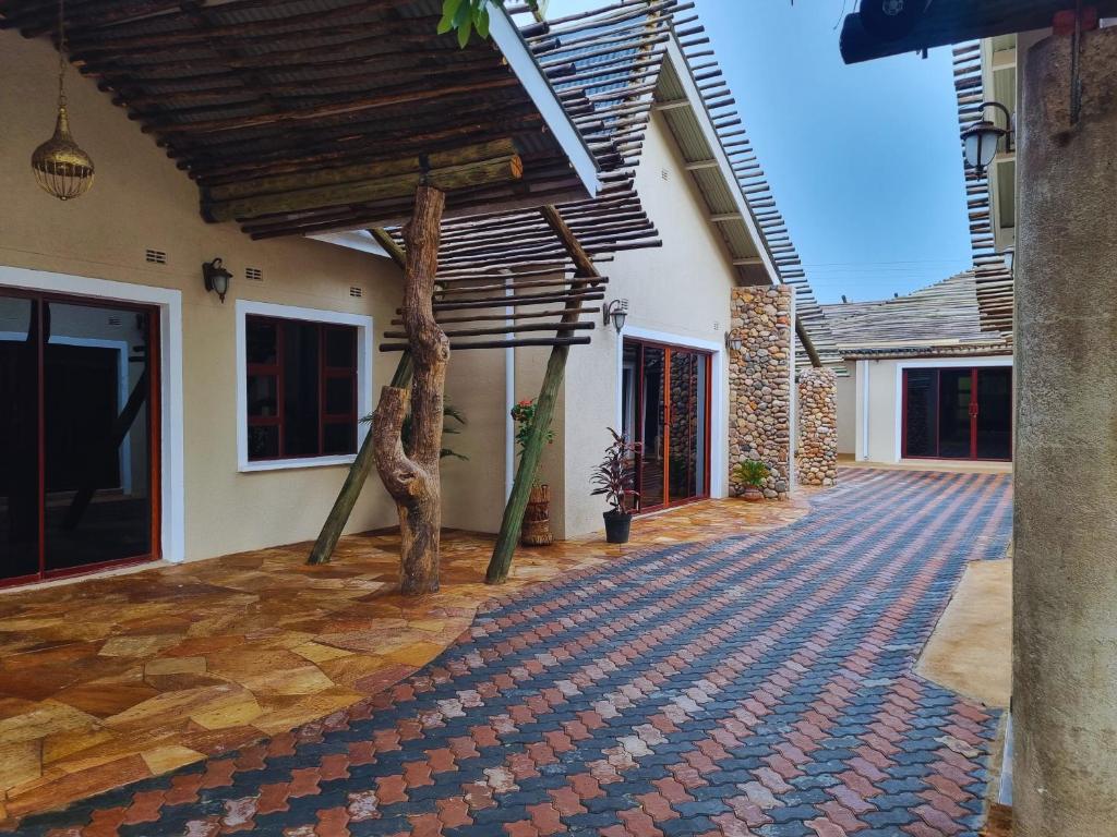 a courtyard of a house with a wooden roof at Wild Haven Lodge in Victoria Falls