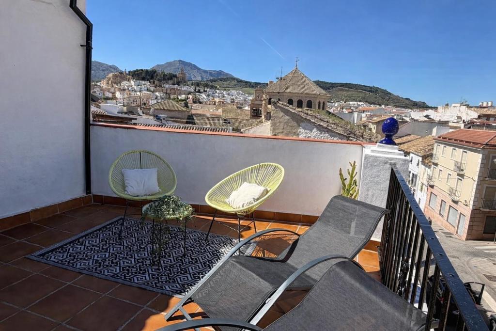 a balcony with chairs and a view of a city at CASA VERA, Casa completa para familias o grupos en el centro de Antequera in Antequera