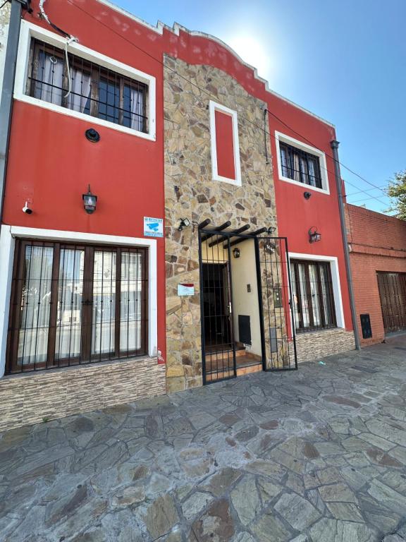 a red building with a door on a street at Hostal Tierra del Sol in Salta