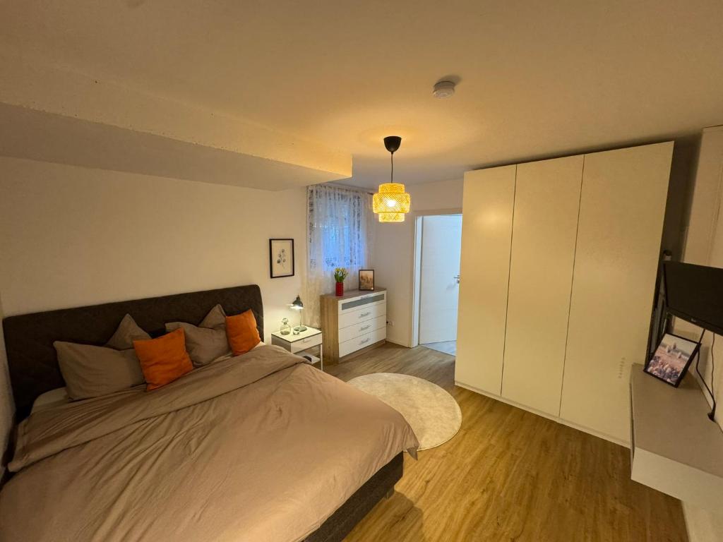 a bedroom with a bed and a television in it at Schöne Wohnung mit eigenem Eingang Souterrain in Walldorf