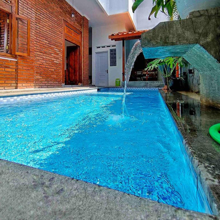 a swimming pool with a water fountain in a house at Sabi House Danu, Family Home near Prawirotaman in Timuran